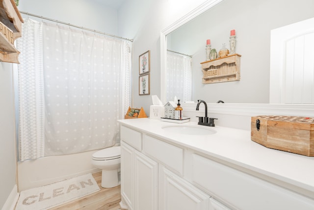 bathroom featuring shower / bath combination with curtain, wood finished floors, vanity, and toilet