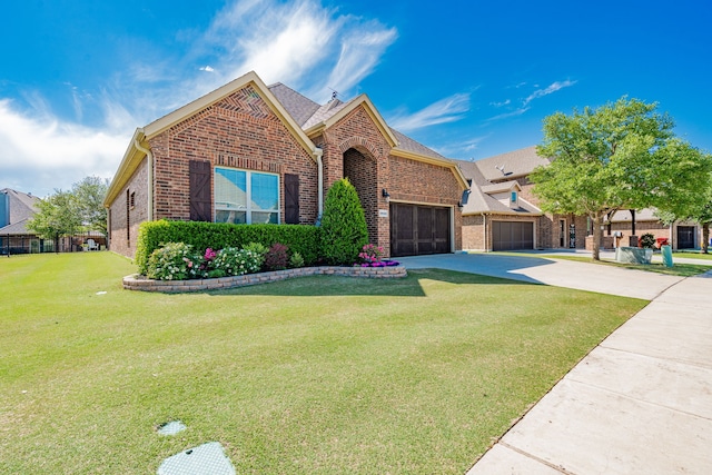 ranch-style house featuring brick siding, a front yard, a garage, and concrete driveway