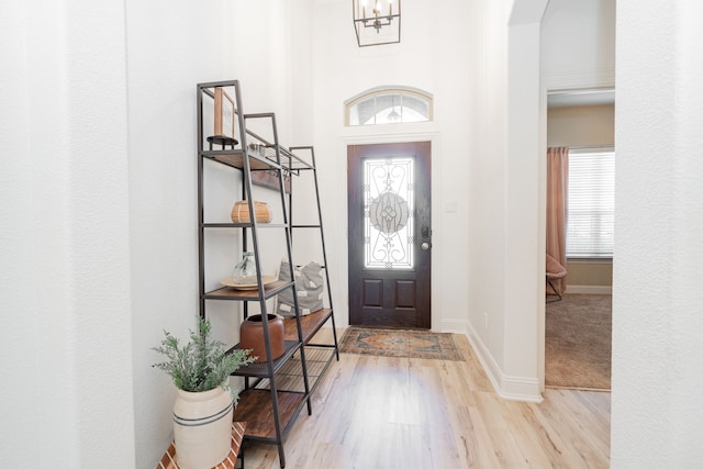 entrance foyer with plenty of natural light, baseboards, wood finished floors, and arched walkways
