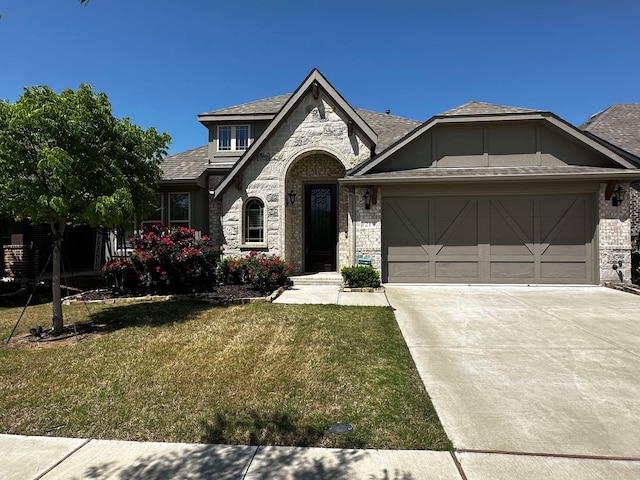 1217 Timber Grove Ter, Little Elm, TX 76227 - view of front facade with an attached garage, driveway, stone siding, and a front yard