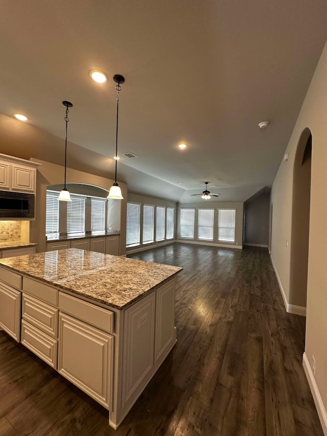 1217 Timber Grove Ter, Little Elm, TX 76227 - kitchen with ceiling fan, black microwave, a center island, baseboards, and dark wood-style flooring