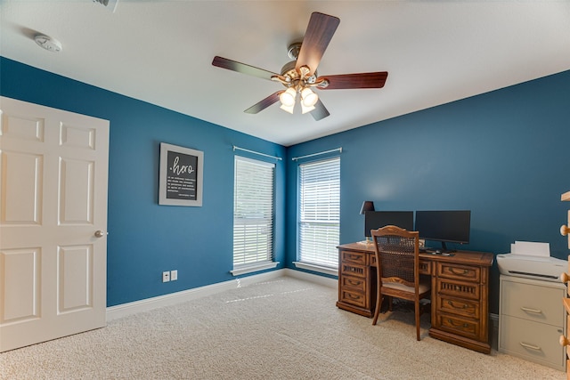 carpeted home office featuring baseboards and a ceiling fan