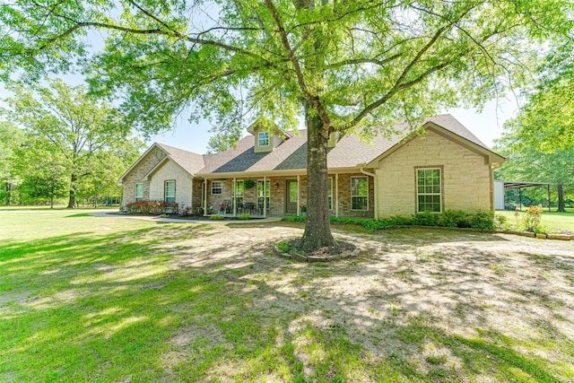 ranch-style home featuring roof with shingles, stone siding, and a front lawn