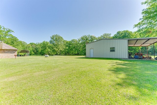 view of yard featuring a pole building, an outbuilding, and a carport