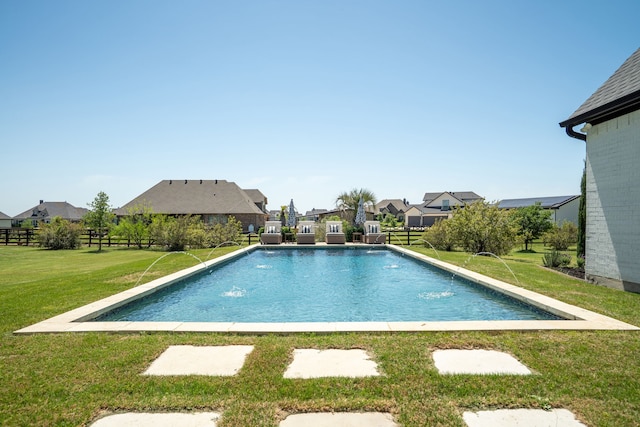 outdoor pool featuring fence, a lawn, and a residential view