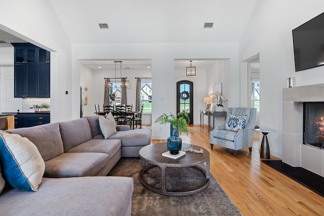 3325 Sandpiper Cir, Northlake, TX 76226 - living area featuring light wood-style flooring, lofted ceiling, and a lit fireplace