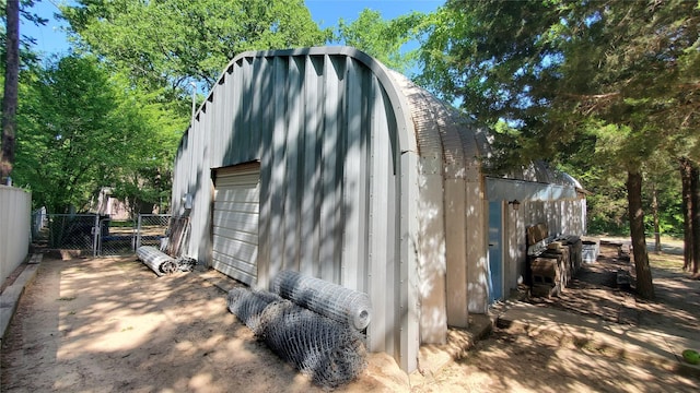 view of outdoor structure featuring fence and an outbuilding