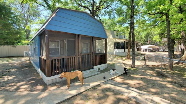 exterior space with a sunroom and fence