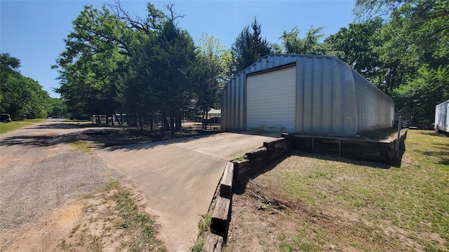 view of outbuilding featuring concrete driveway and an outdoor structure