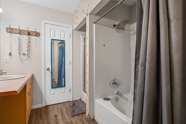 full bath with wood finished floors, a textured ceiling, vanity, and shower / bathtub combination with curtain