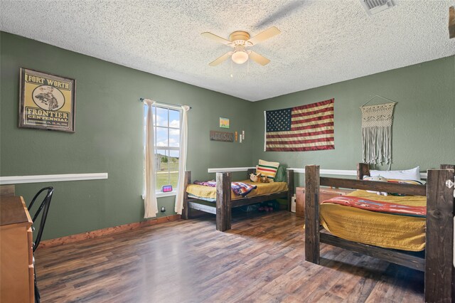 bedroom featuring visible vents, a ceiling fan, wood finished floors, and a textured ceiling