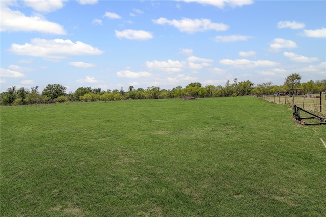 view of yard featuring a rural view and fence
