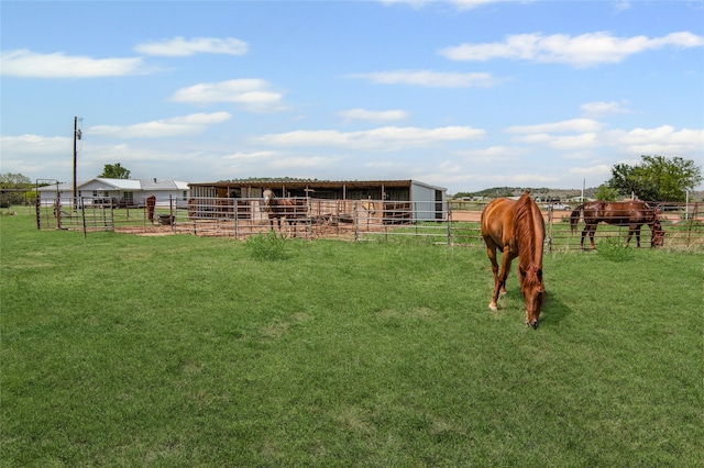 view of yard featuring a rural view, an outbuilding, and an exterior structure