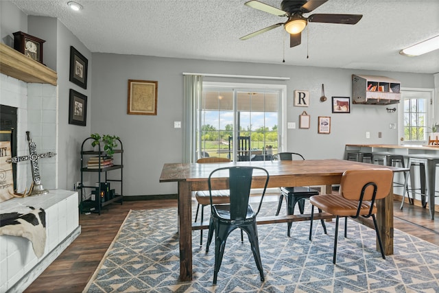 dining area with wood finished floors, a textured ceiling, and ceiling fan