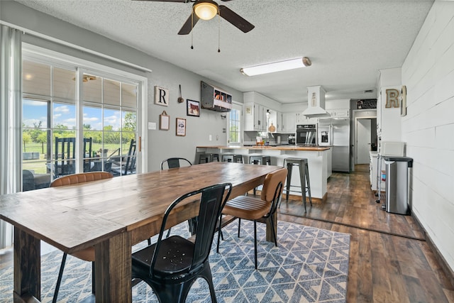 dining room featuring a ceiling fan, a textured ceiling, and dark wood-style flooring