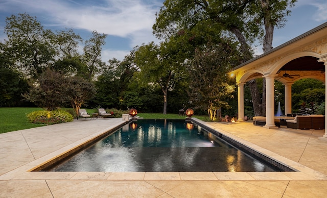 outdoor pool with a patio area and ceiling fan