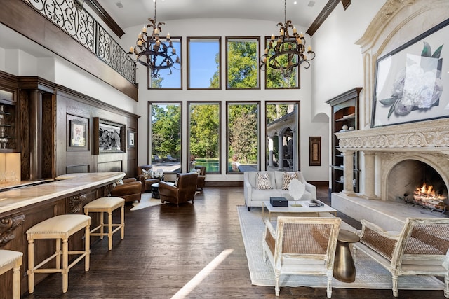 living area featuring dark wood-type flooring, high vaulted ceiling, a chandelier, and a high end fireplace