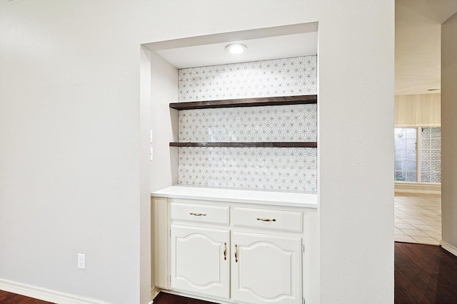 room details with baseboards, wood finished floors, and decorative backsplash