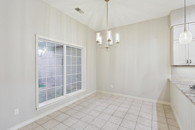 unfurnished dining area featuring a chandelier, visible vents, baseboards, and light tile patterned floors