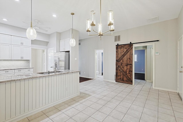 kitchen with backsplash, visible vents, a sink, stainless steel refrigerator with ice dispenser, and ceiling fan with notable chandelier