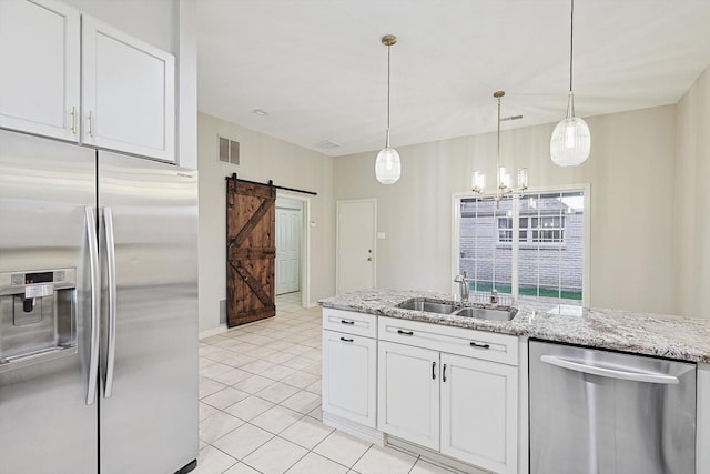 kitchen featuring a barn door, a sink, white cabinetry, appliances with stainless steel finishes, and visible vents
