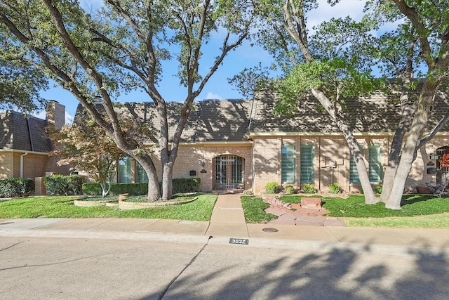 3027 Squireswood Dr, Carrollton, TX 75006 - view of front of house featuring brick siding, a front lawn, and french doors