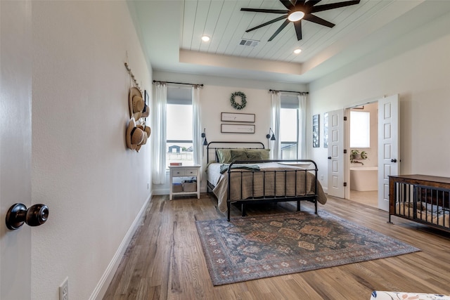 120 Southern Ct, Springtown, TX 76082 - bedroom featuring a tray ceiling, visible vents, baseboards, wood finished floors, and ensuite bath