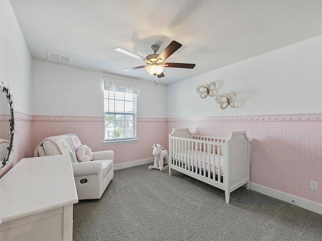 220 Glenwood Dr, Oak Point, TX 75068 - bedroom featuring ceiling fan, visible vents, a nursery area, wainscoting, and carpet floors