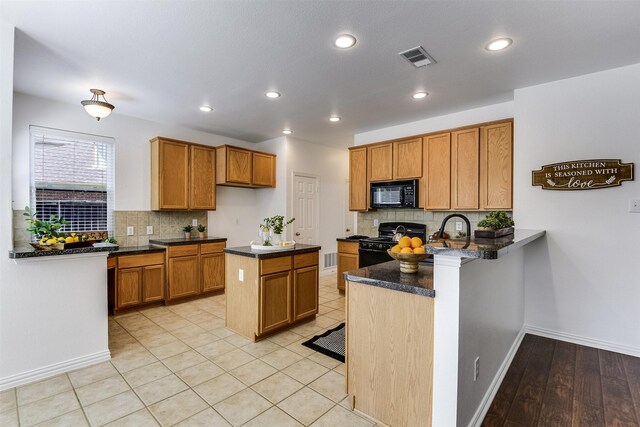 6807 Lagoon Dr, Grand Prairie, TX 75054 - kitchen with black appliances, decorative backsplash, brown cabinetry, a peninsula, and recessed lighting