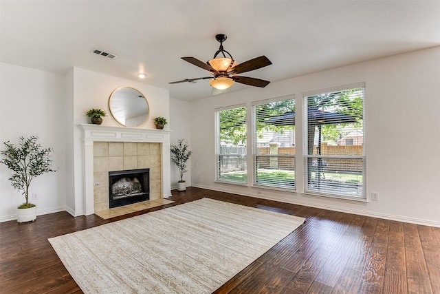 6807 Lagoon Dr, Grand Prairie, TX 75054 - unfurnished living room featuring dark wood-style flooring, baseboards, ceiling fan, and a tiled fireplace