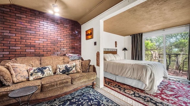 bedroom with brick wall and access to exterior