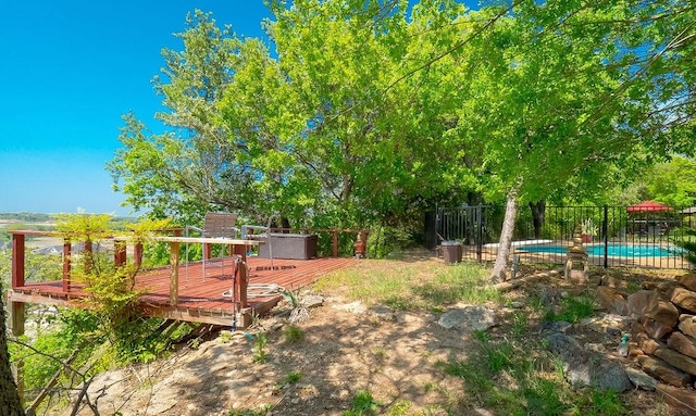 view of yard featuring fence, a deck, and a fenced in pool