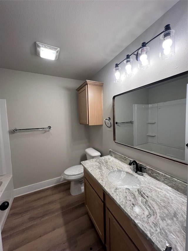 bathroom with toilet, baseboards, wood finished floors, a shower, and vanity