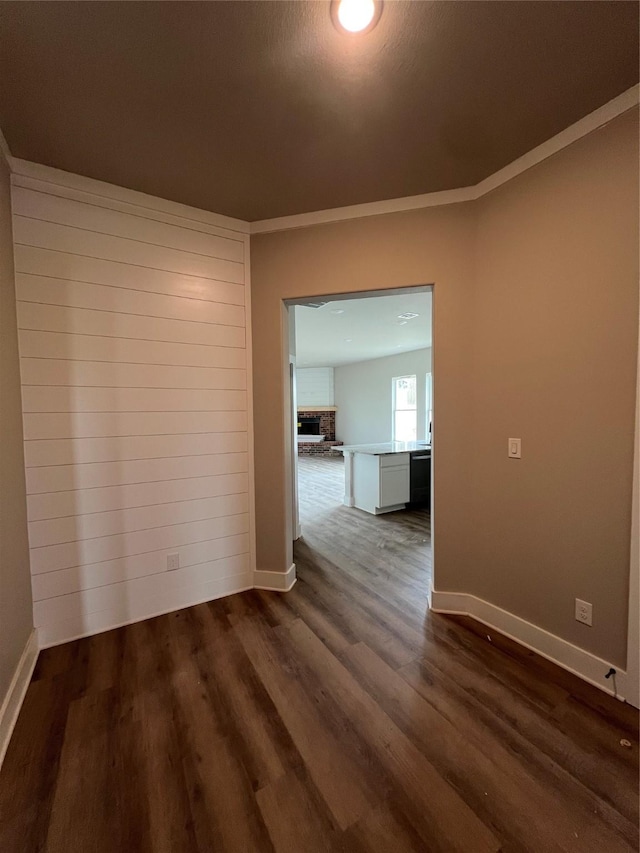 unfurnished room with baseboards and dark wood-style floors