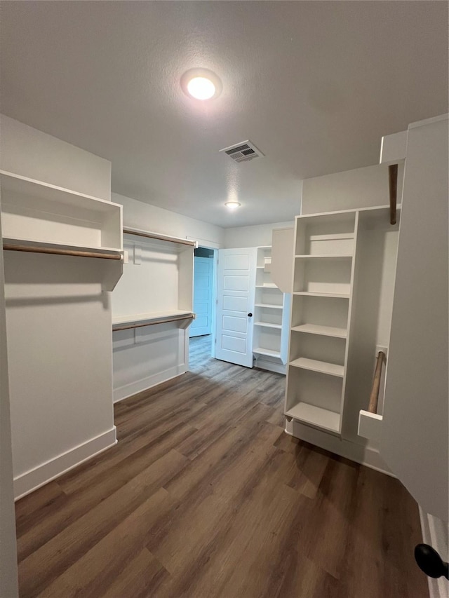 spacious closet with visible vents and dark wood-style flooring