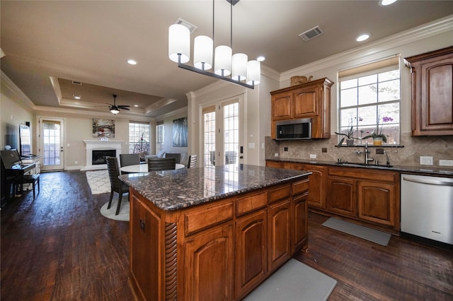 2905 White Dove Dr, Plano, TX 75093 - kitchen featuring appliances with stainless steel finishes, ornamental molding, dark wood-type flooring, a raised ceiling, and a ceiling fan