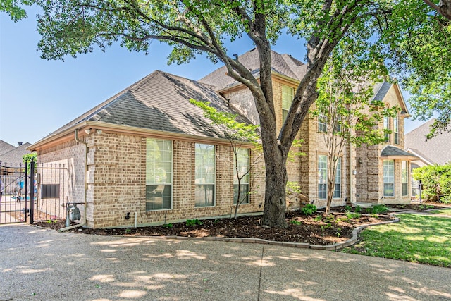 7905 Vista Ridge Dr S, Fort Worth, TX 76132 - view of side of home featuring brick siding, a shingled roof, fence, and a gate