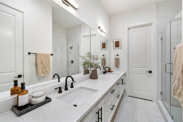 bathroom featuring double vanity, marble finish floor, a stall shower, and a sink