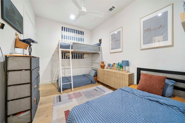bedroom featuring baseboards, visible vents, light wood-style floors, and ceiling fan