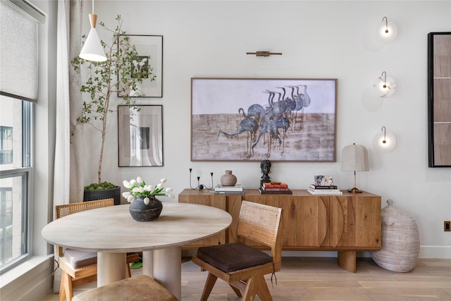dining room with baseboards and light wood-type flooring