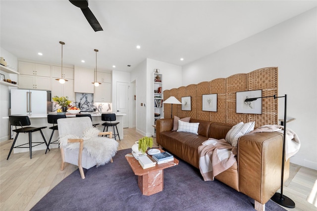 living area featuring light wood-style flooring, baseboards, and recessed lighting