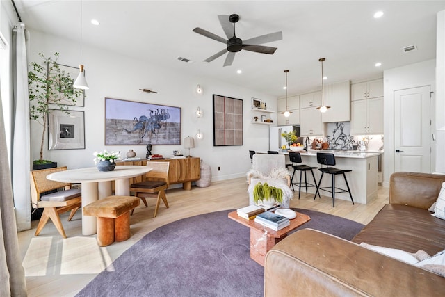 living area with a ceiling fan, visible vents, recessed lighting, and light wood-style flooring