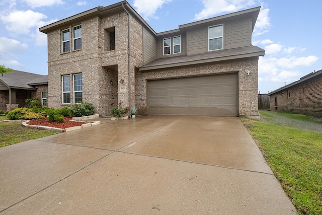 traditional-style home with driveway, a front lawn, brick siding, and an attached garage