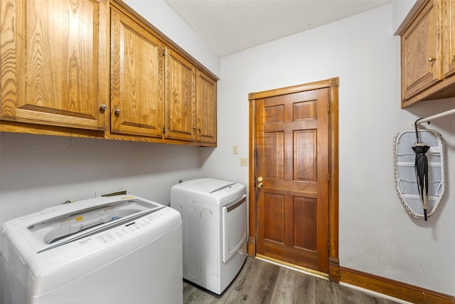 clothes washing area with cabinet space, independent washer and dryer, and wood finished floors