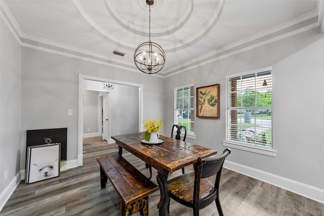 dining area featuring a notable chandelier, crown molding, and a tray ceiling