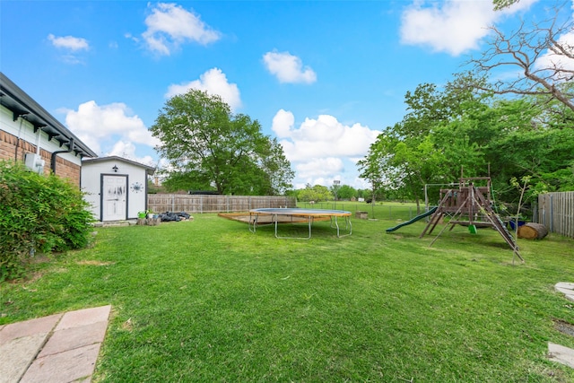 view of yard with a fenced backyard, a playground, a shed, and a trampoline