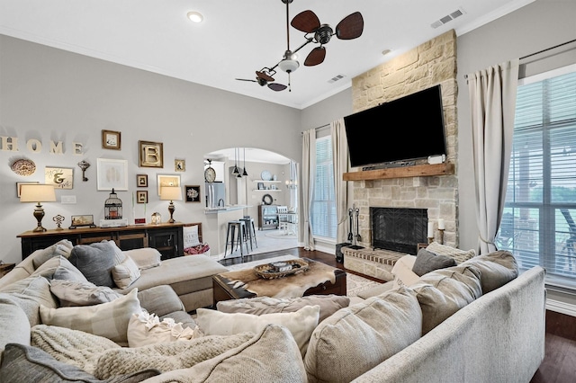 living room featuring dark wood finished floors, visible vents, a wealth of natural light, and ornamental molding