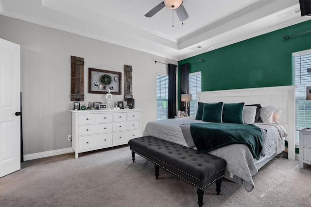 bedroom featuring carpet flooring, visible vents, a ceiling fan, crown molding, and a raised ceiling