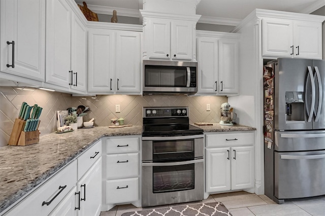 kitchen with light stone counters, white cabinetry, and stainless steel appliances