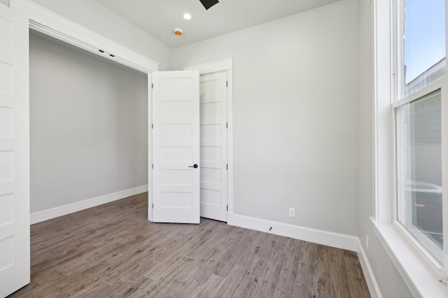 unfurnished room featuring recessed lighting, light wood-style floors, and baseboards
